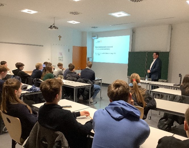 Schülerinnen und Schüler lauschen einem Mitglied des Rotary Clubs.