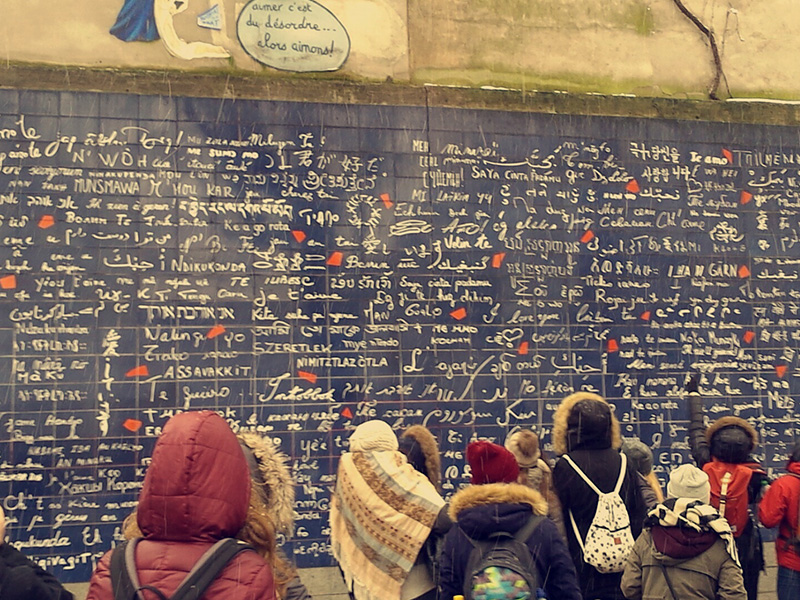 Schülerinnen und Schüler stehen vor der "Mur de je t'aime" in Paris.