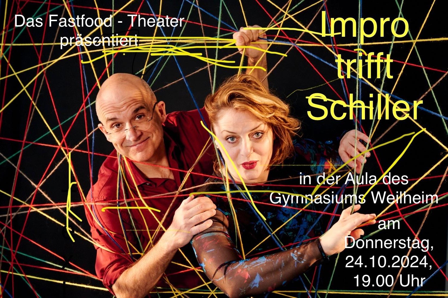 Zu sehen sind eine Schauspielerin und ein Schauspieler des Fastfood-Theaters München, die aus einer Wand aus Fäden richtung Kamera blicken.