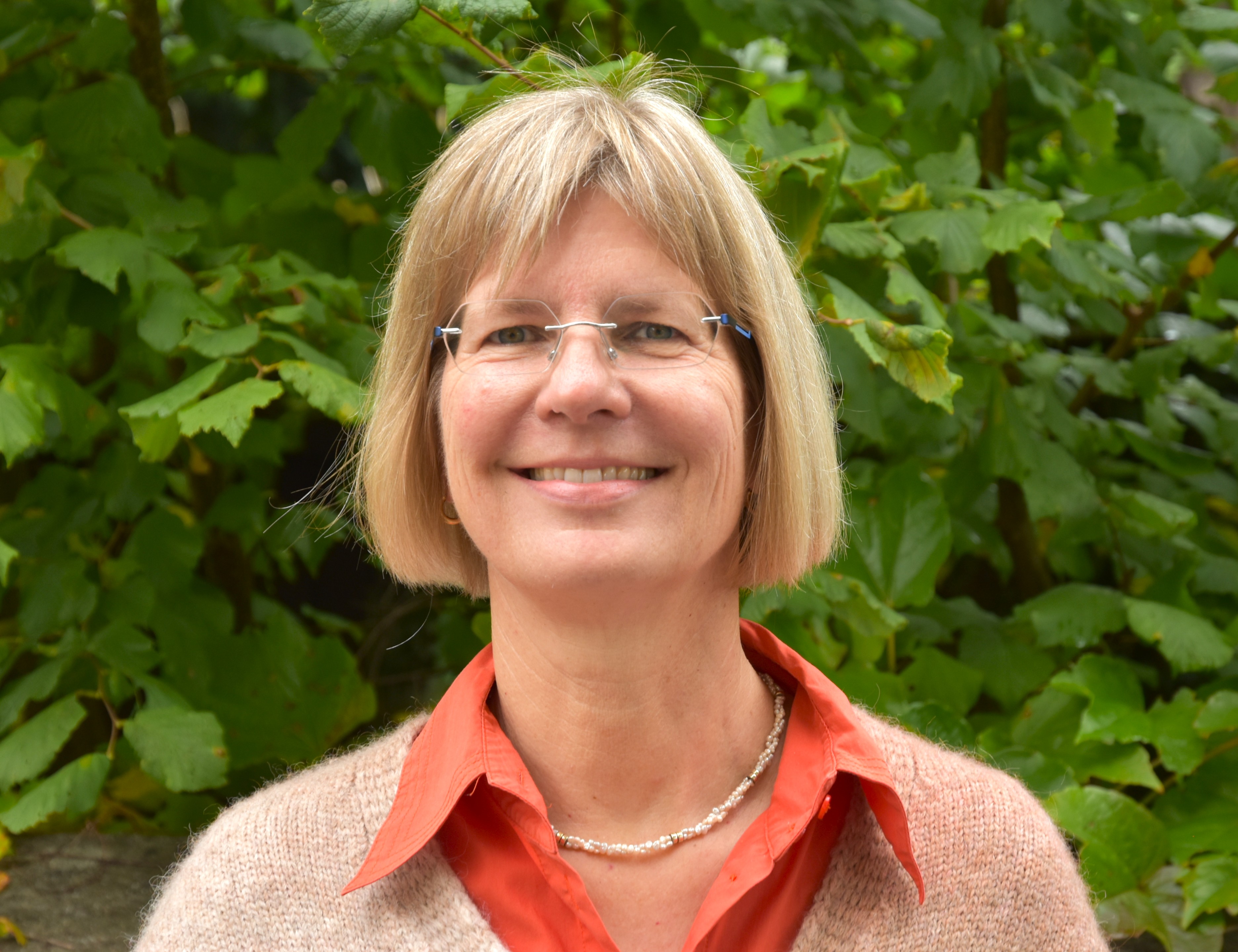 Porträt eines Mitglieds der Erweiterten Schulleitung, aufgenommen vor einem blauen Hintergrund.