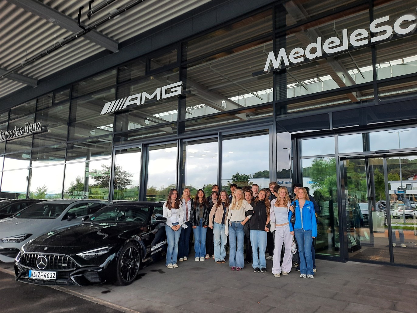 Zu sehen sind Schülerinnen und Schüler der Klasse 9c bei einer Betriebsbesichtigung bei beim Mercedes-Benz Autohaus Medele-Schäfer.