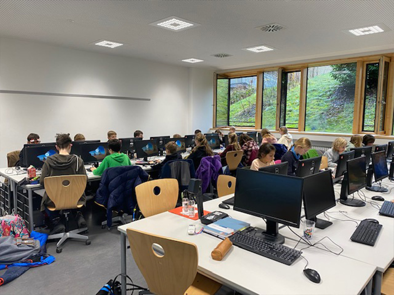Im Computerraum des Gymnasiums arbeiten Kinder konzentriert an den Computern und vertiefen ihre digitalen Kompetenzen.