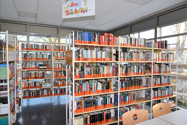 Eine Vielzahl von Bücherreihen füllt den Raum der Bibliothek und lädt dazu ein, in verschiedenen Themenwelten zu stöbern. 