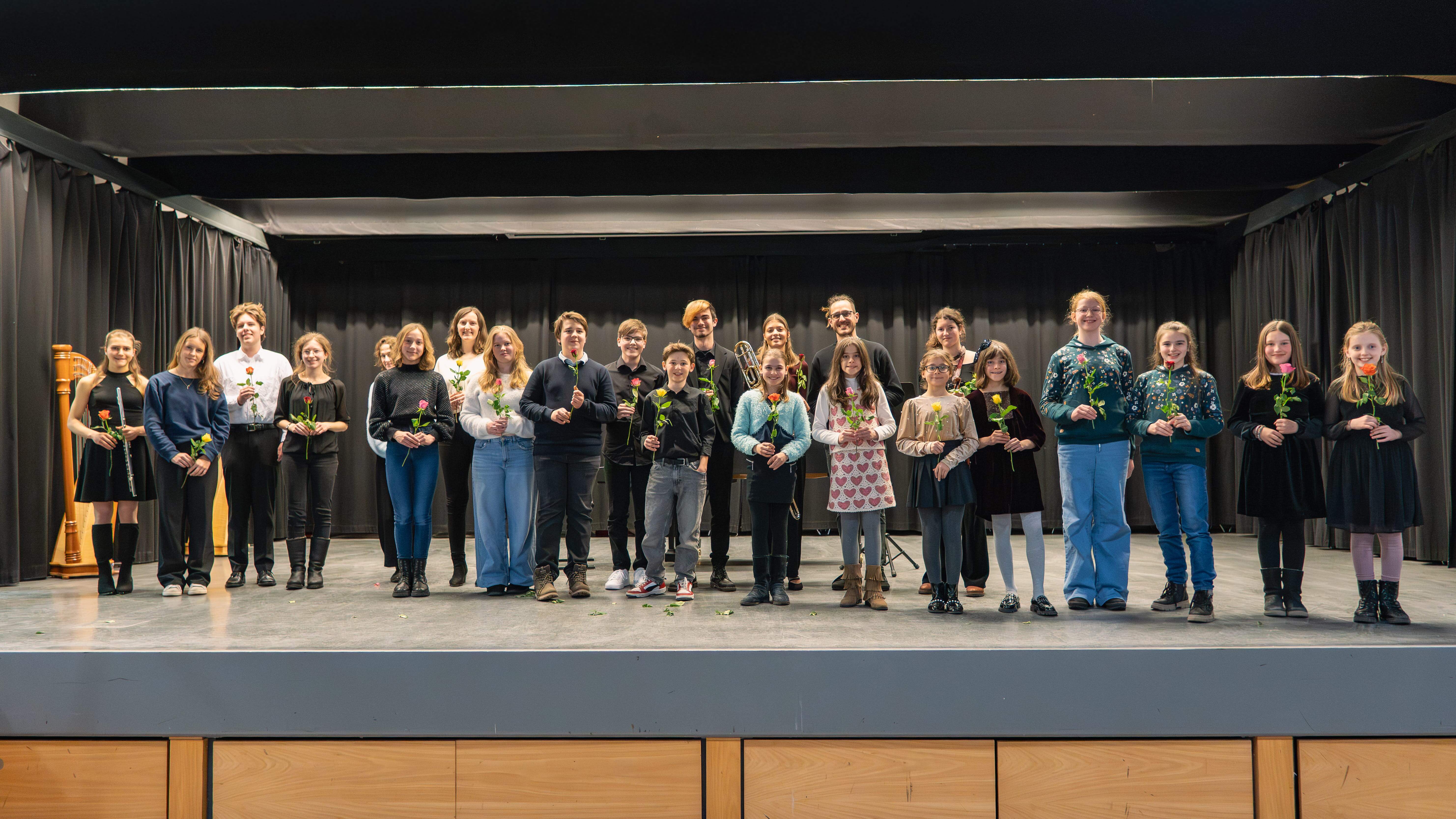 Sch&uuml;lerinnen und Sch&uuml;ler auf der B&uuml;hne der Aula bei Musik um 7