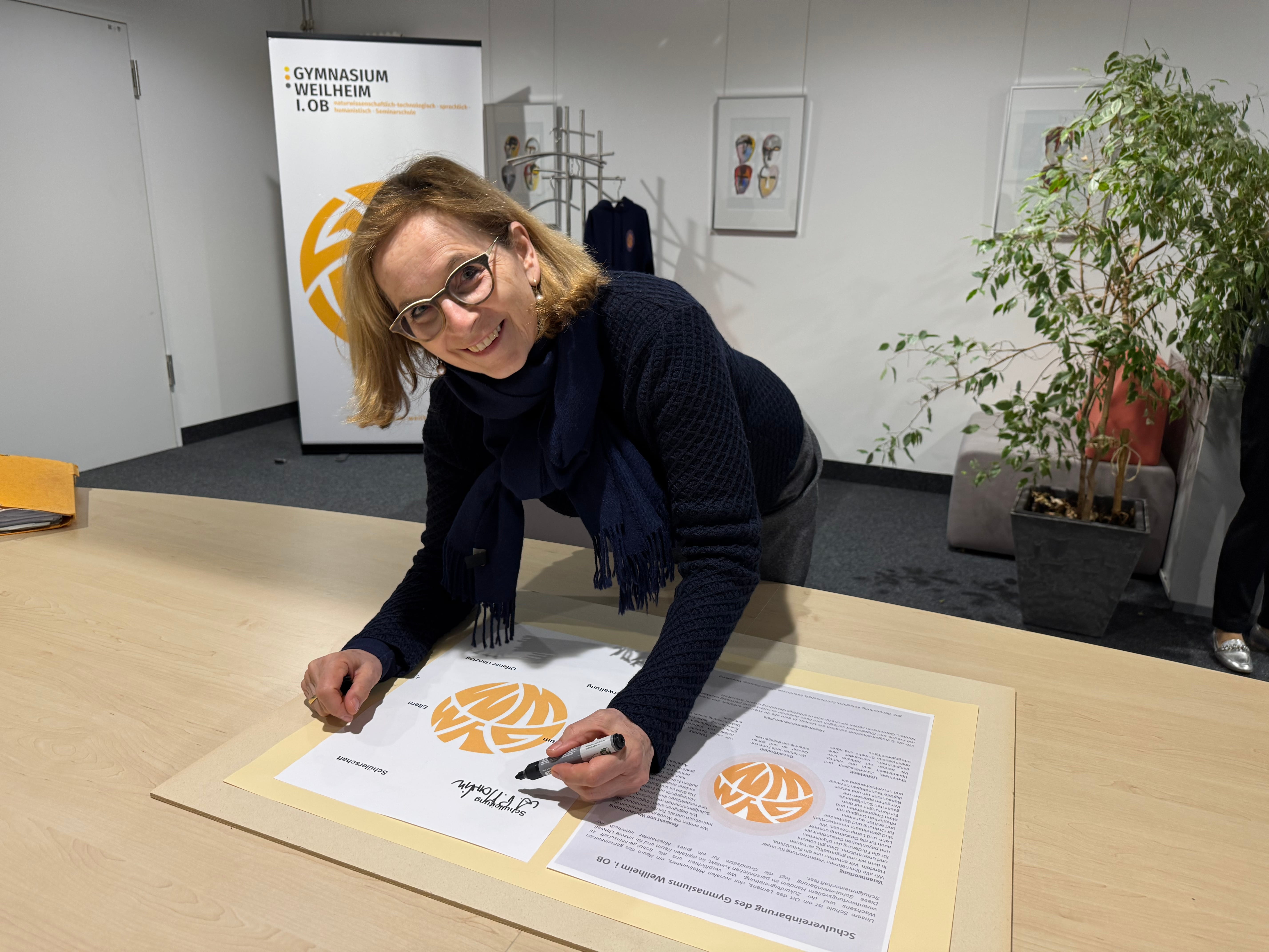Zu sehen ist die Schulleiterin Frau Martin bei der Unterzeichnung der Schulvereinbarung