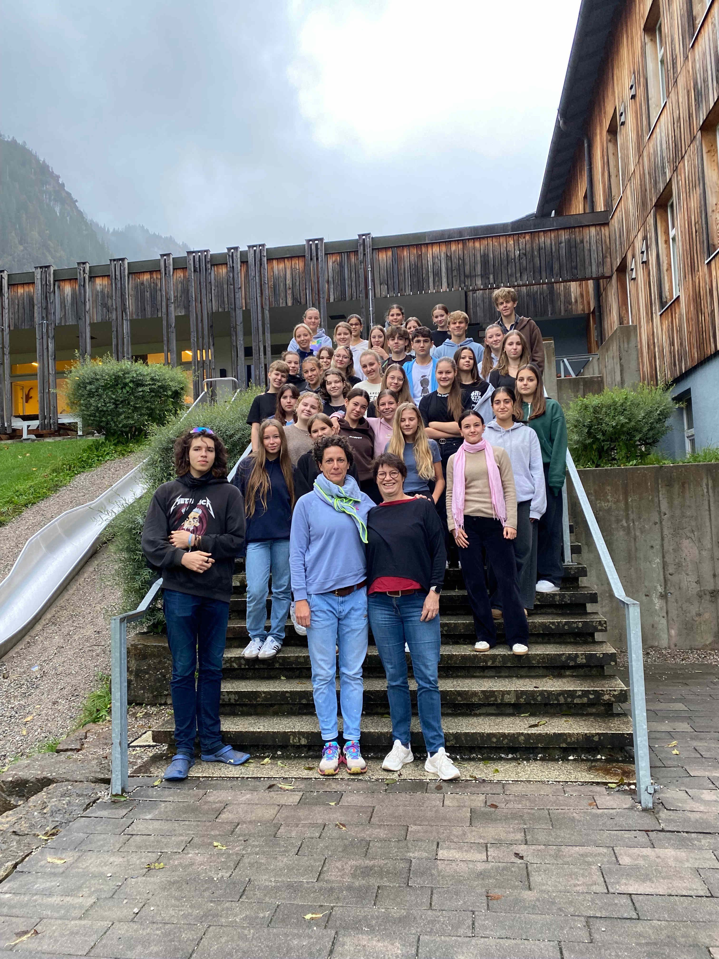 Die Schülerinnen und Schüler der SMV stehen mit ihren Leiterinnen vor der DJH Jugendherberge Oberammergau.